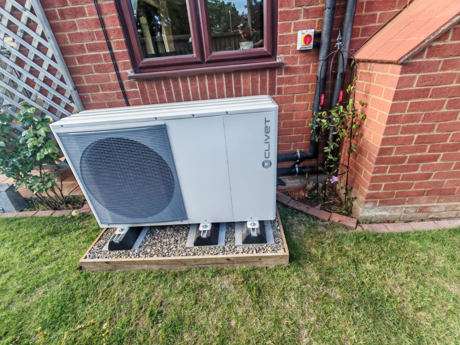 Clivet air source heat pump installed at a red-brick home